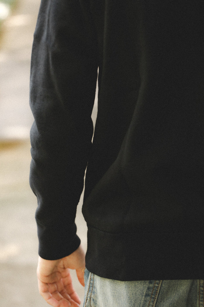 Person wearing a black hoodie with a blurred background