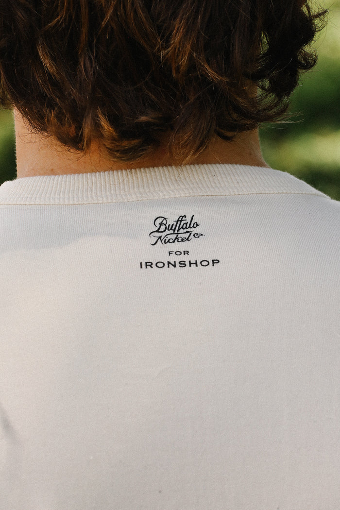 Back view of cream loopwheel tee with Buffalo Nickel Co. for Ironshop logo near collar