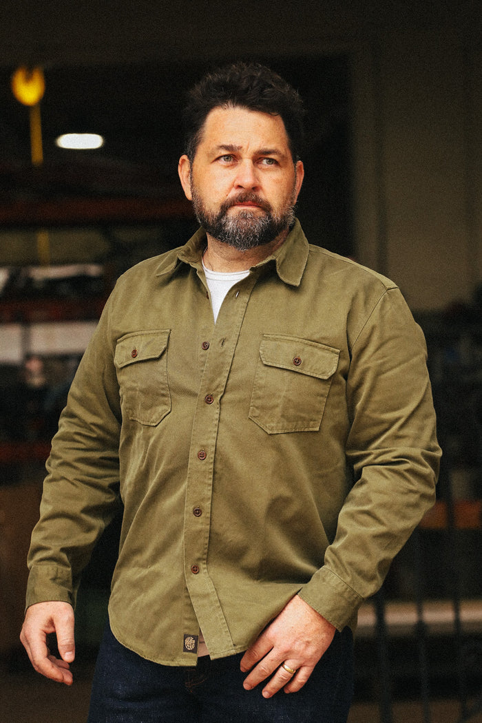 Man wearing a green jacket in an indoor setting