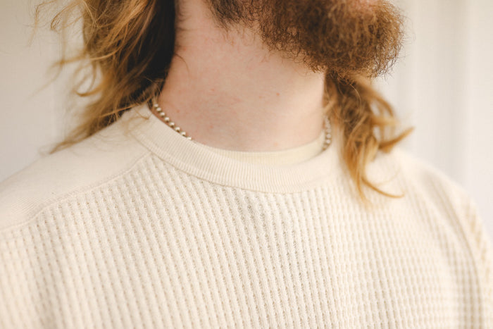 Person wearing a beige sweater with a blurred background