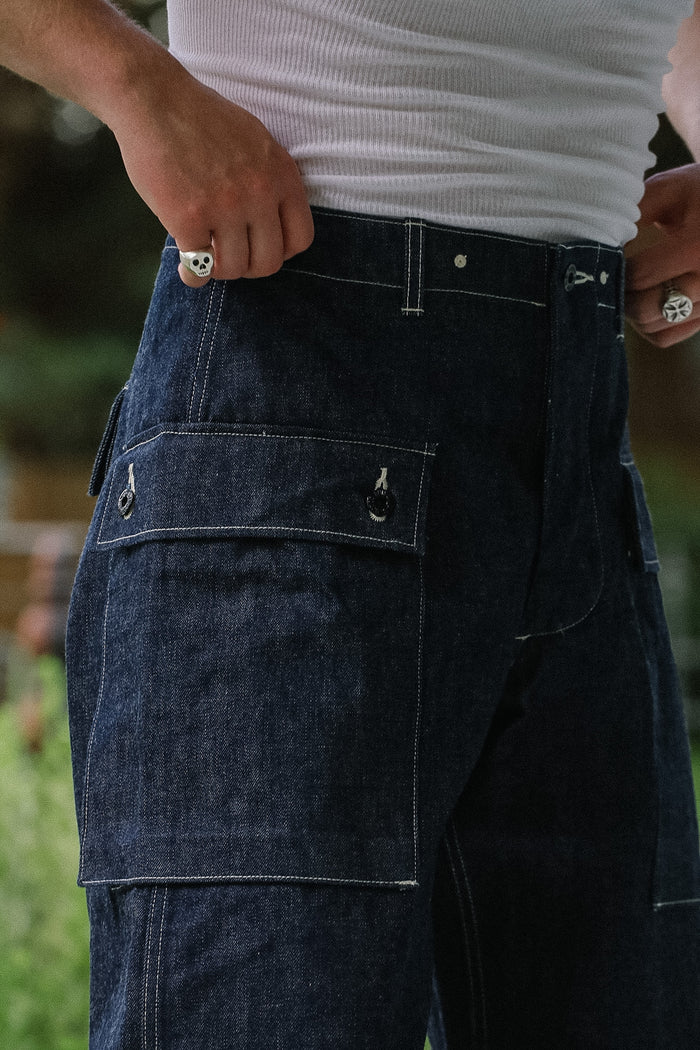 Person wearing dark blue jeans with a blurred background