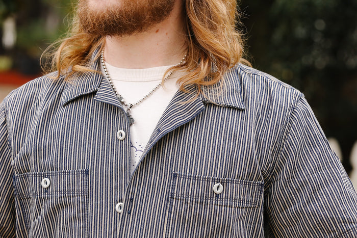 Person wearing a striped shirt with a blurred background