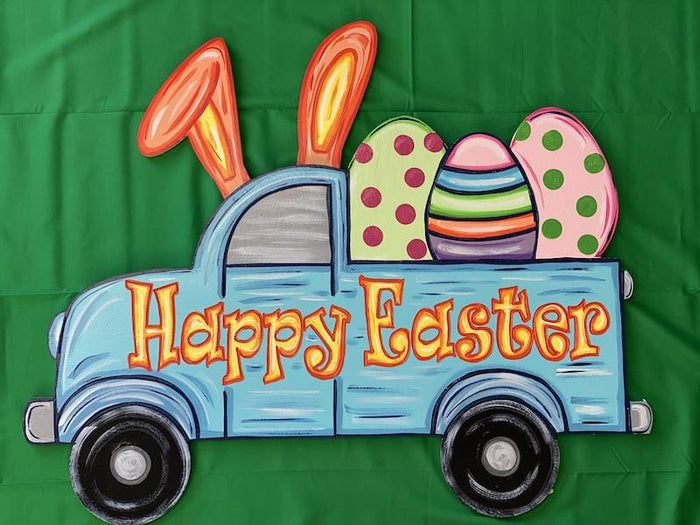 Blue truck with bunny ears that had three colorful easter eggs in the back