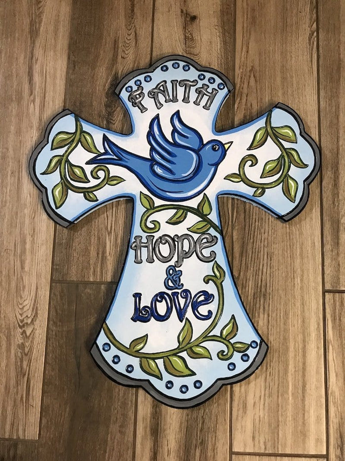 A customizable DIY yard art cross with 'Faith, Hope, and Love' text, featuring a blue bird and green leaves on a gray background.