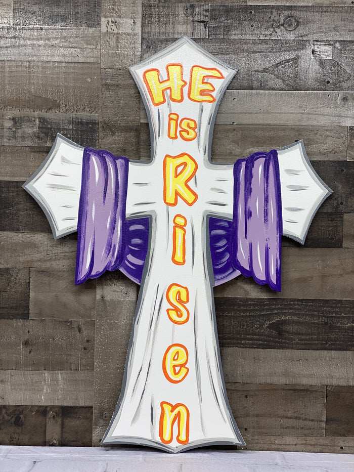 he is risen white sign with purple scarf draped across the sides