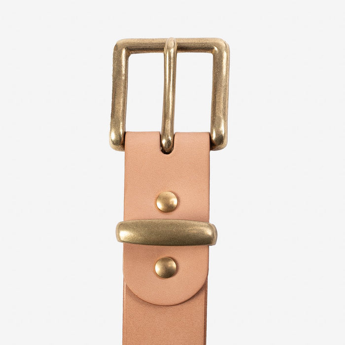 Natural leather belt with brass buckle and rivets on white background