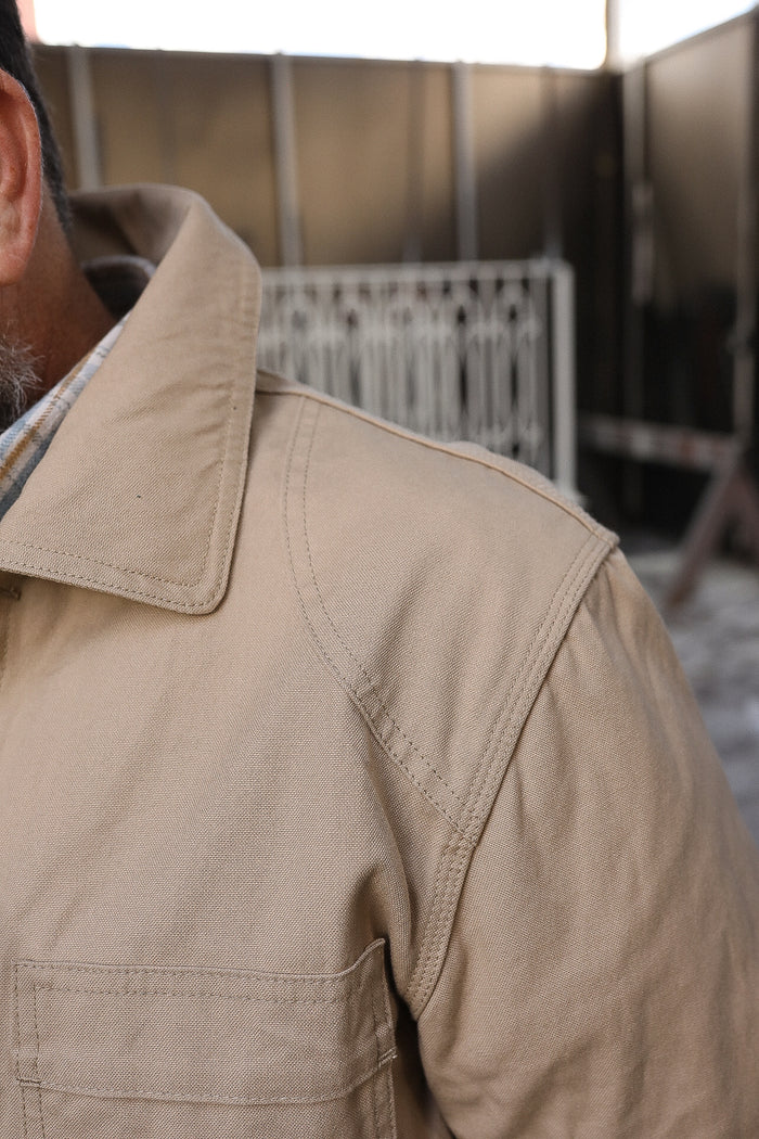 Close-up of a tan durable work jacket shoulder and collar with detailed stitching from Iron Shop Provisions