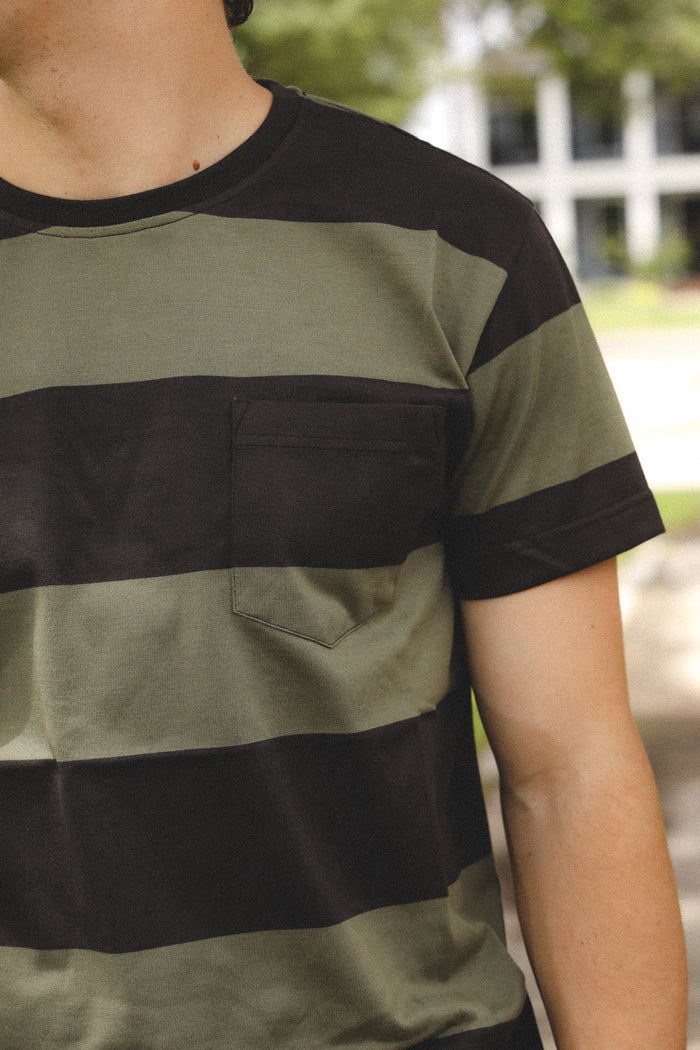 Person wearing a green and black striped shirt outdoors