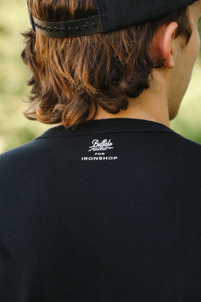 Close-up of a person wearing a black tee with Buffalo Nickel Co. for Ironshop printed on the back neckline