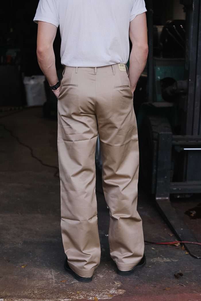 person wearing khaki pants on a dark background