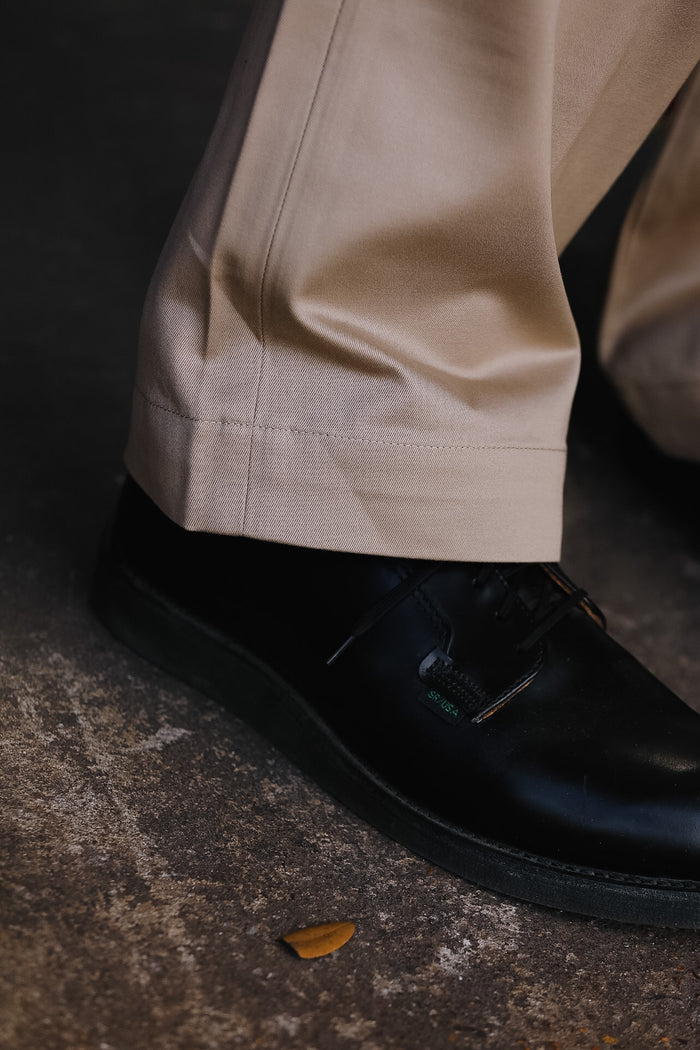 up close of beige pant and black shoe