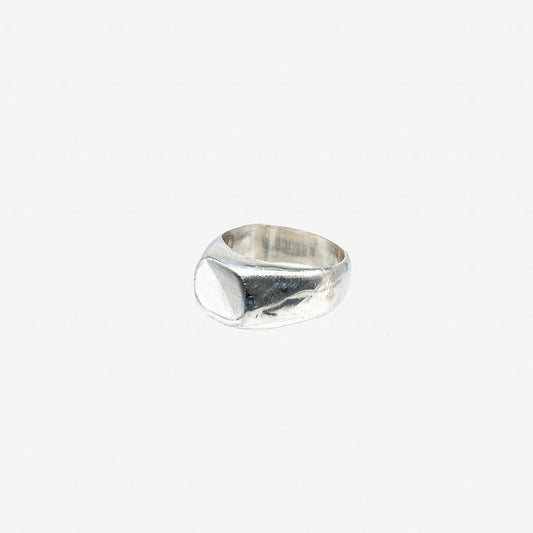 Minimalist hammered silver signet ring on white background from Iron Shop Provisions