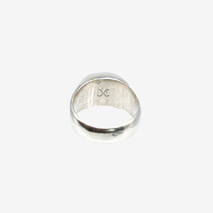 Silver ring with a minimalist crossed design engraved inside, photographed on white background