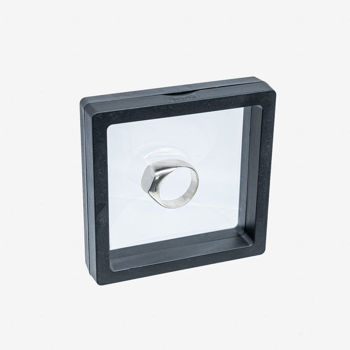 Silver metal signet ring displayed in a black frame case with transparent cover on white background