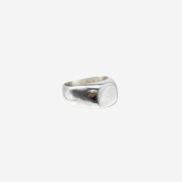 Polished silver signet ring with a smooth, square face on a white background