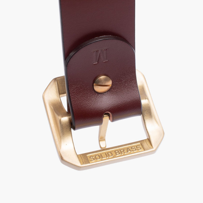 Close-up of brown leather belt with solid brass buckle engraved with "SOLID BRASS"