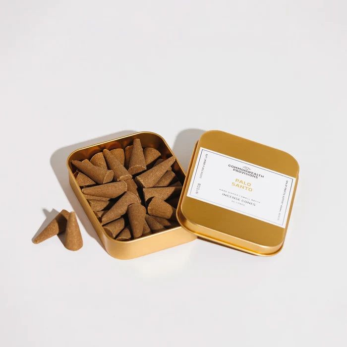 Open gold tin of Palo Santo incense cones with label from Commonwealth Provisions on white background