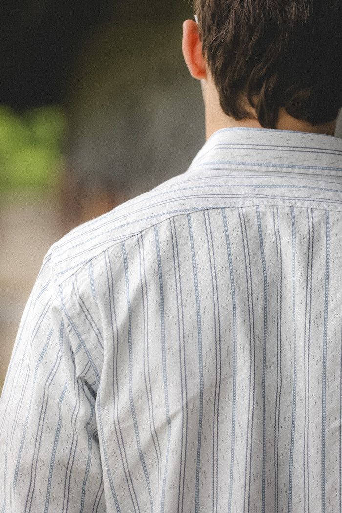 Person wearing a striped shirt with a blurred background