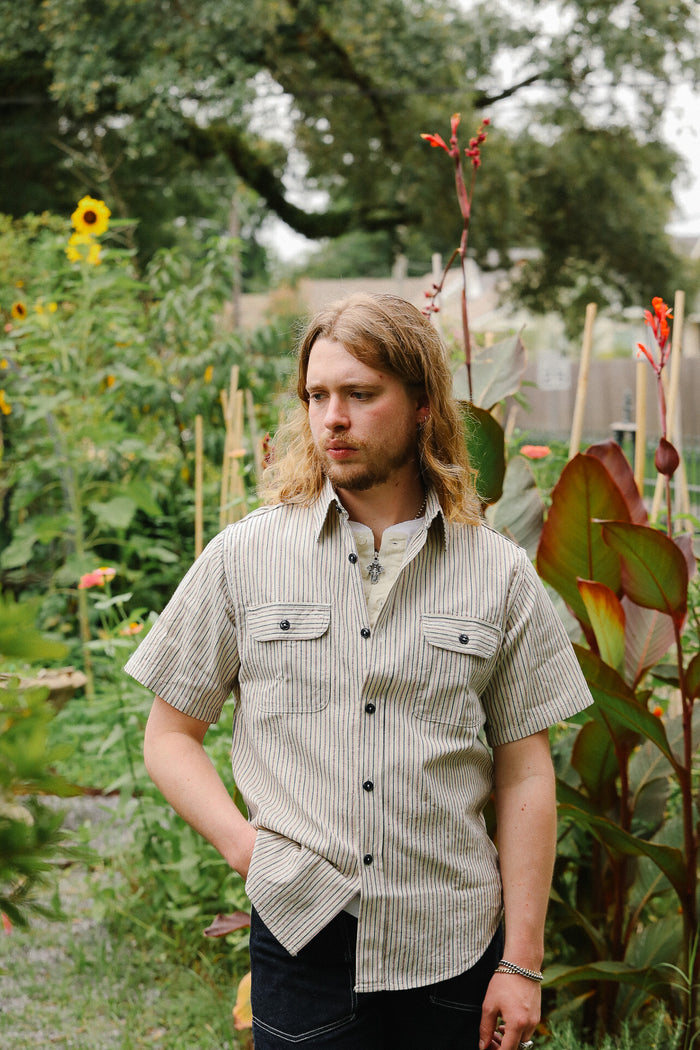 Man standing in a garden with plants and flowers around him