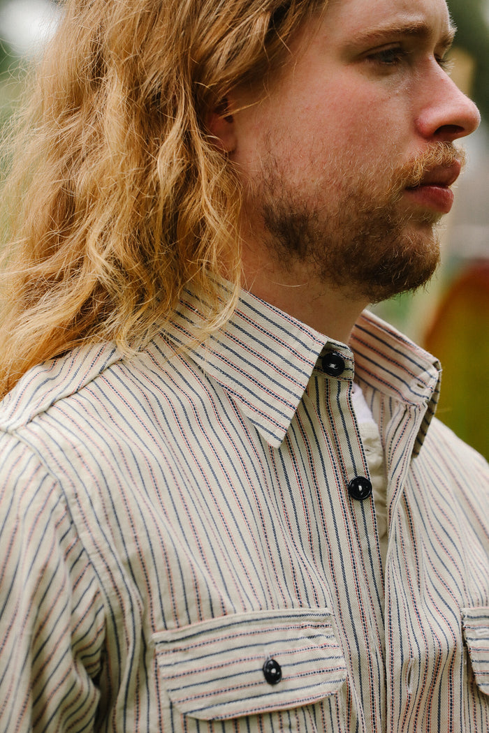 Man wearing a striped shirt with a blurred background