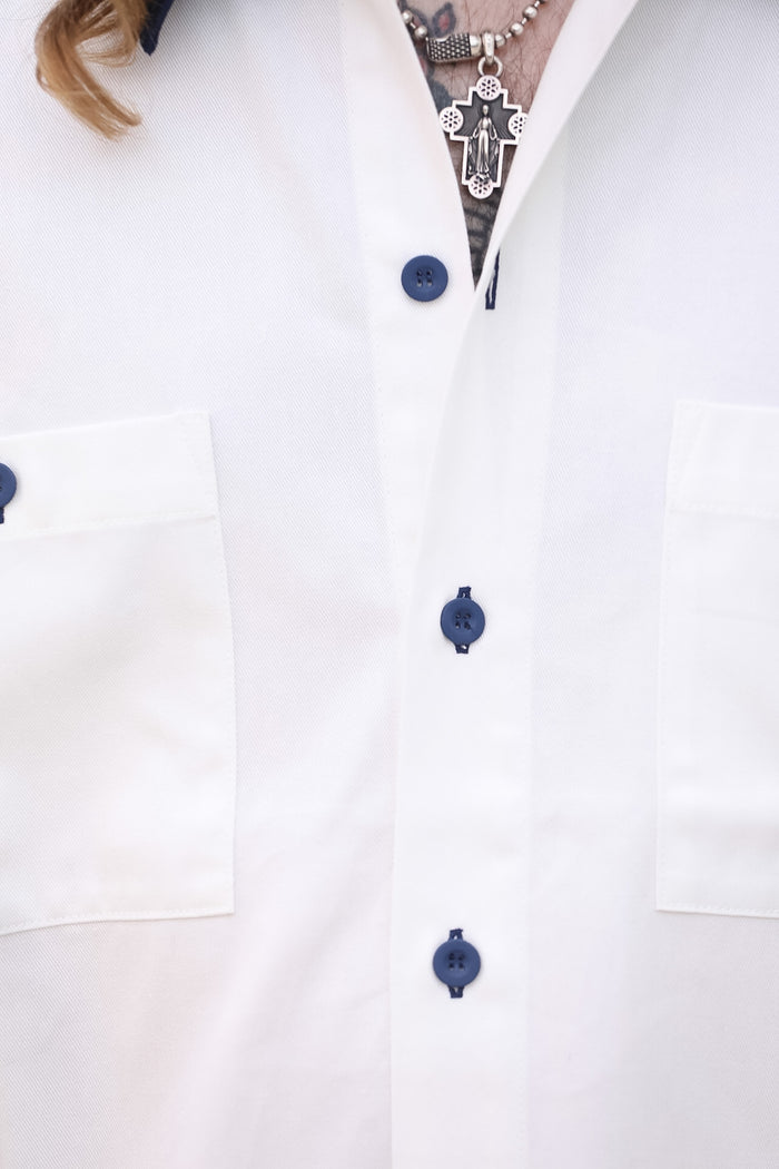 Close-up of a white lab coat with blue buttons