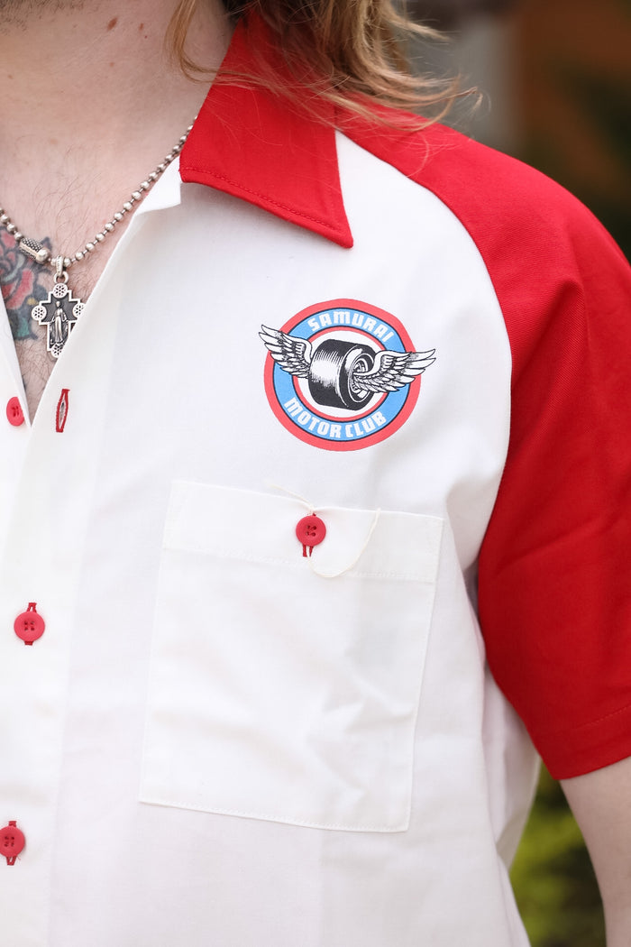 Red and white shirt with a logo on a blurred background