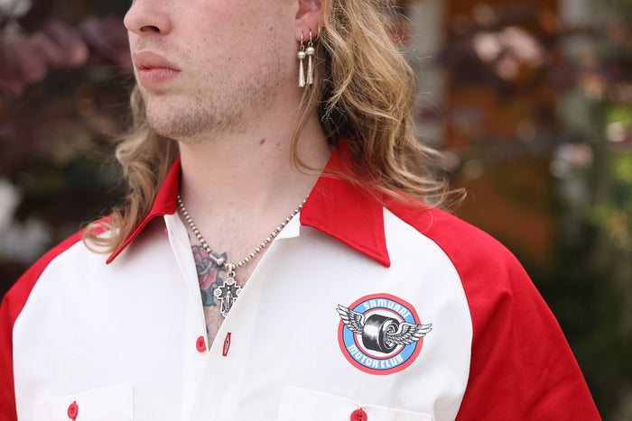 Person wearing a red and white jacket with a logo, blurred background