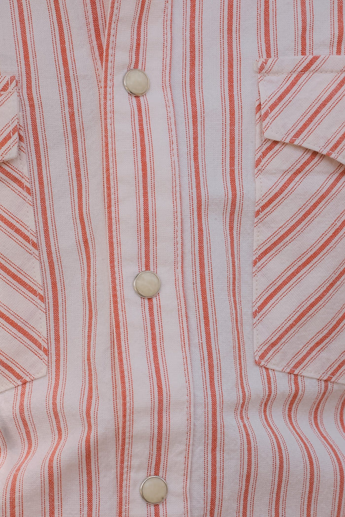 Close-up of a red and white striped shirt with buttons.