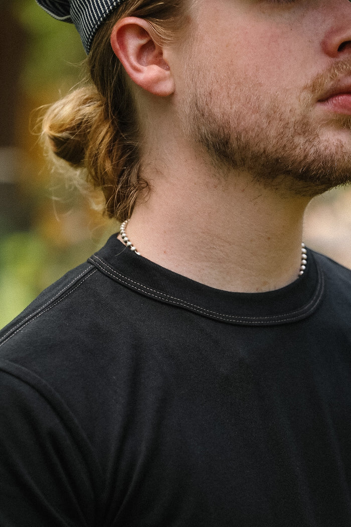 Close-up of a person wearing a black shirt with a blurred background